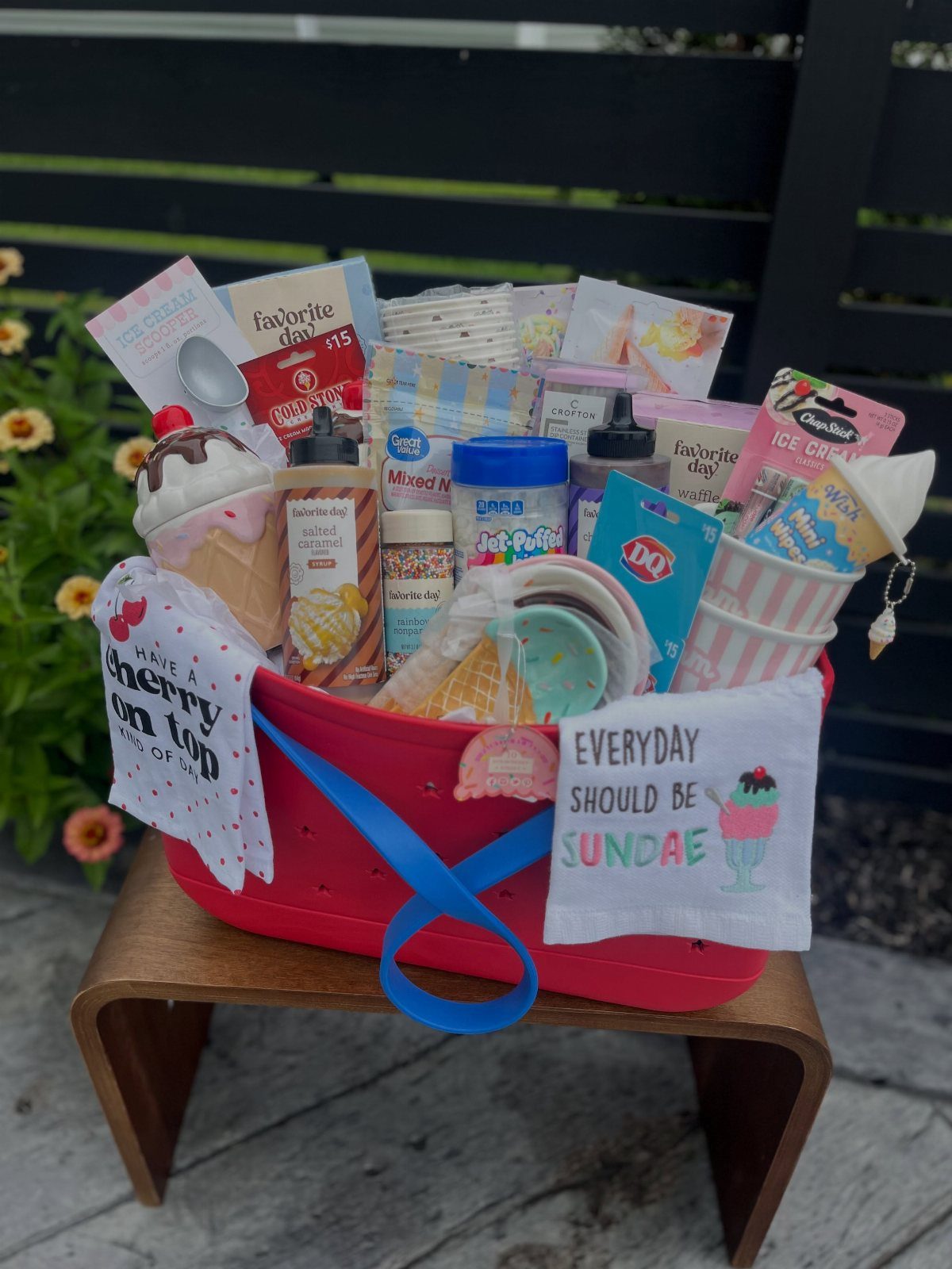 Ice cream themed gift basket in a red tub with toppings and puns.