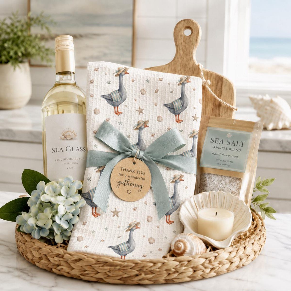 Woven gift basket with white wine, goose-patterned towel, and coastal themed accessories.