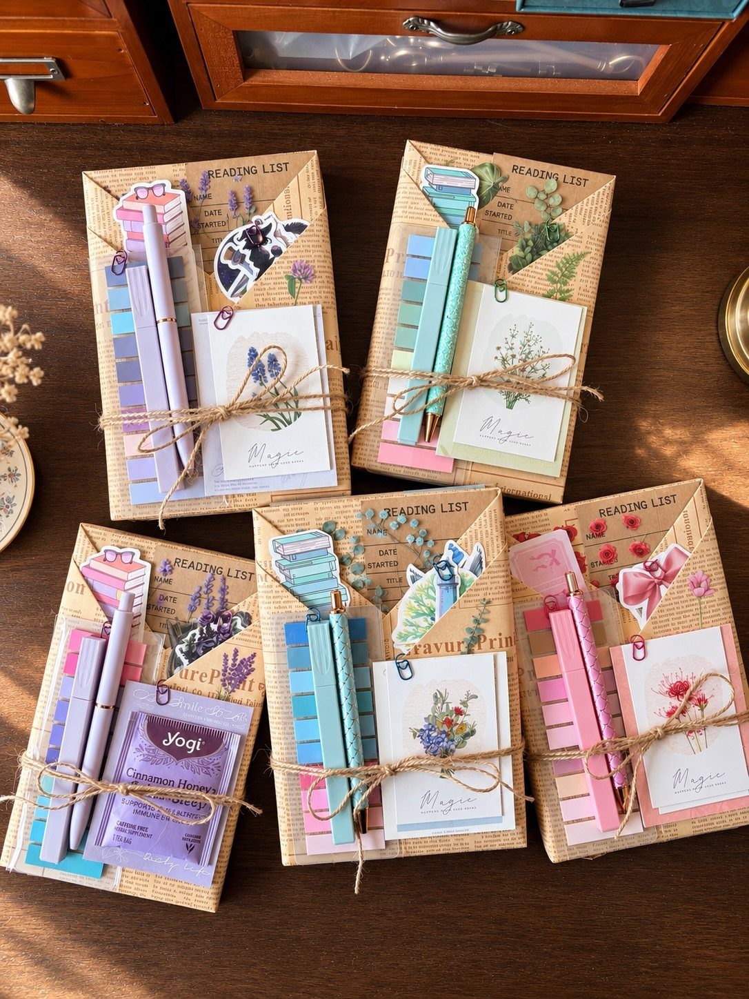 Four brown paper gift bundles with pencils and reading lists on wooden table