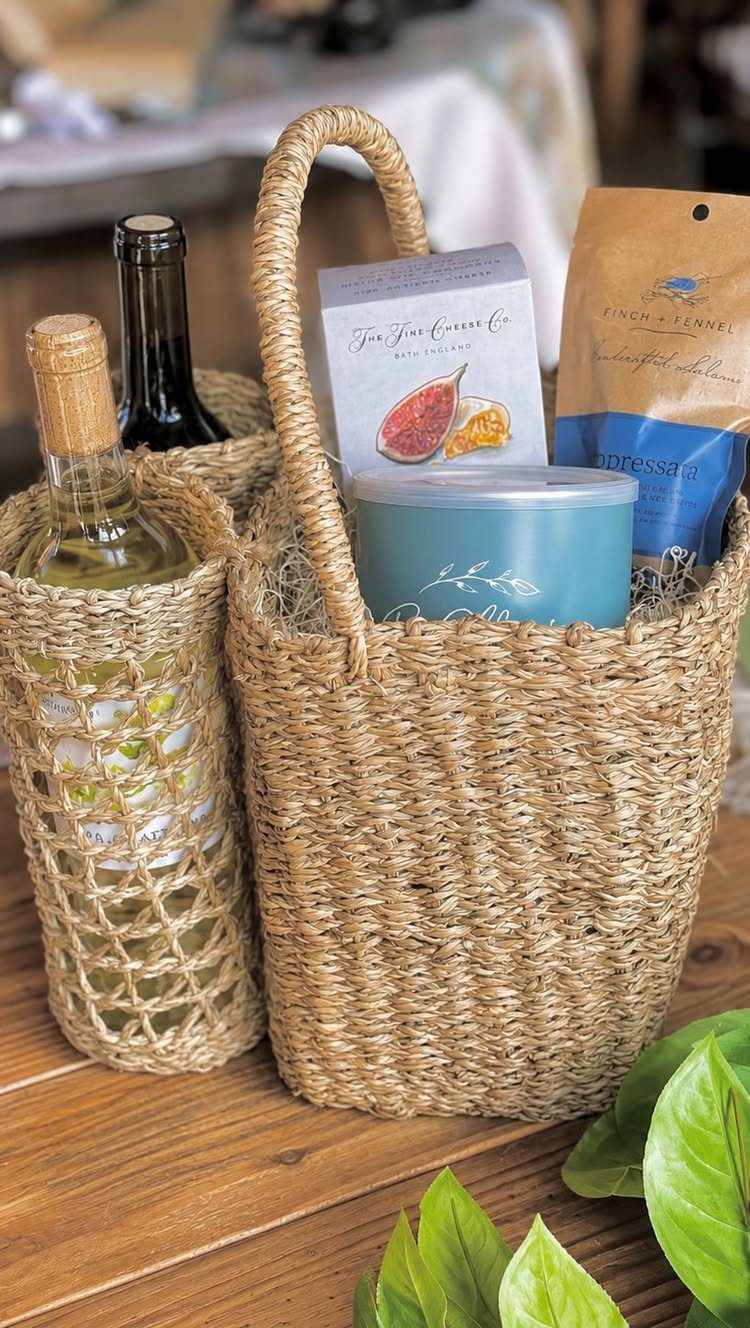 Woven straw gift basket with a blue candle and a bottle of white wine.