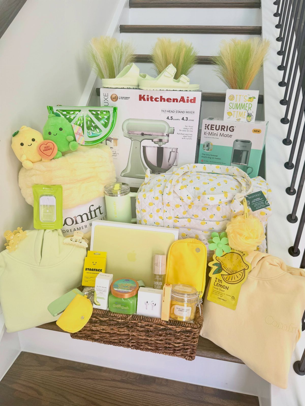 Wicker gift basket filled with yellow and lime green themed summer gifts on stairs.