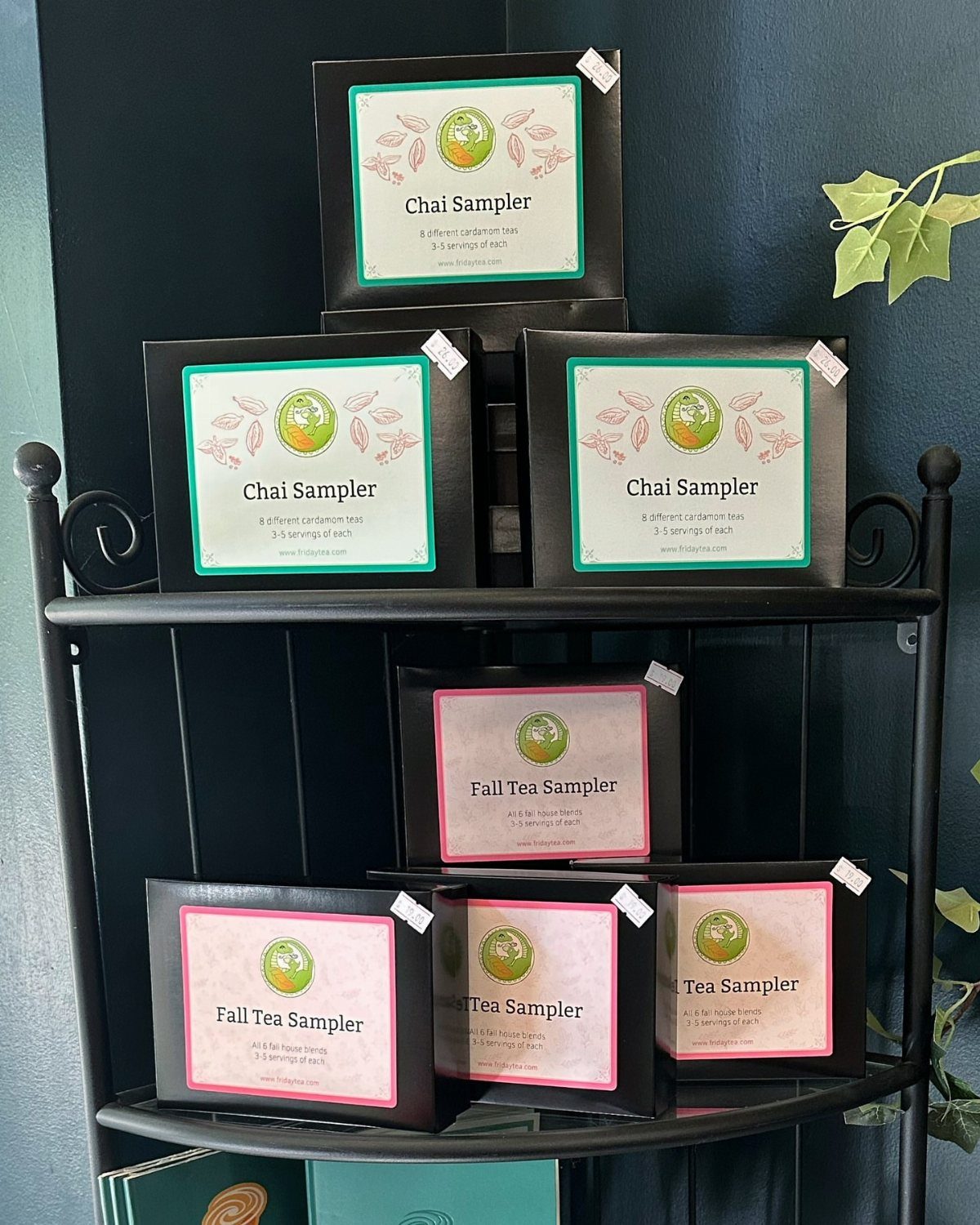 Tea sampler boxes with Chai and Fall labels displayed on a metal shelf.