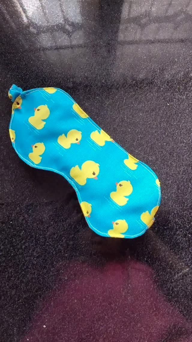 15 Unusual Sewing Gifts to Make for Friends and Family 7 Blue fabric sleep mask with yellow ducks on a dark granite surface