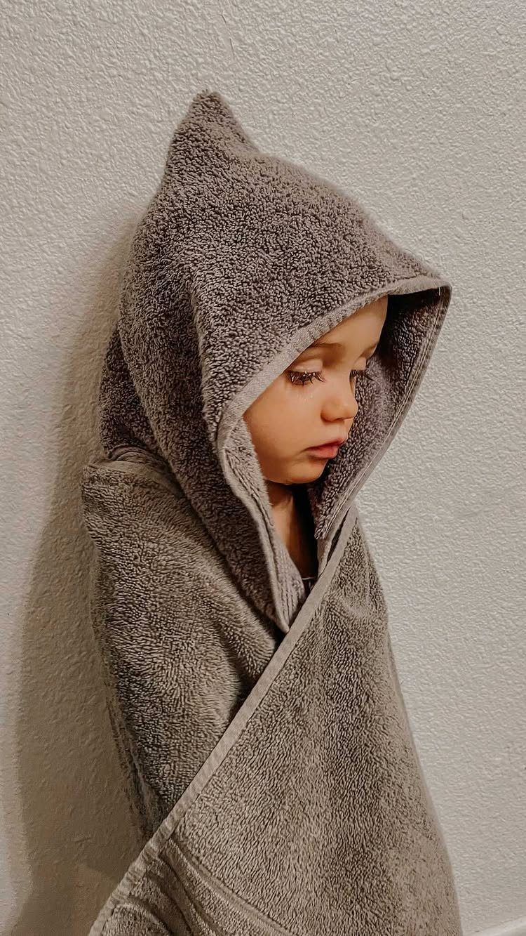 15 Unusual Sewing Gifts to Make for Friends and Family 15 Young child wrapped in a grey hooded terry cloth towel against a wall