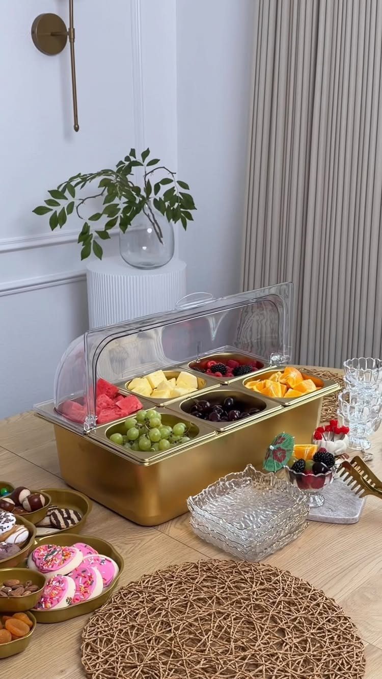 Gold divided serving platter filled with fresh fruit on a wooden table