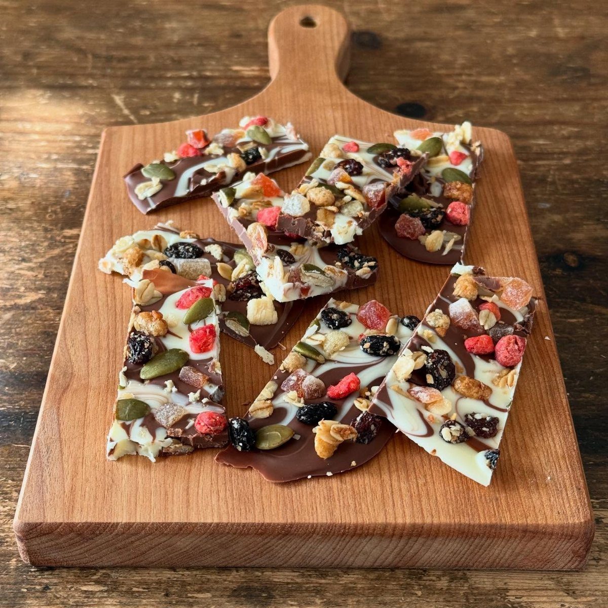 12 Useful Homemade Christmas Gifts People Will Use 8 Chocolate bark with dried fruits and nuts on a wooden cutting board.