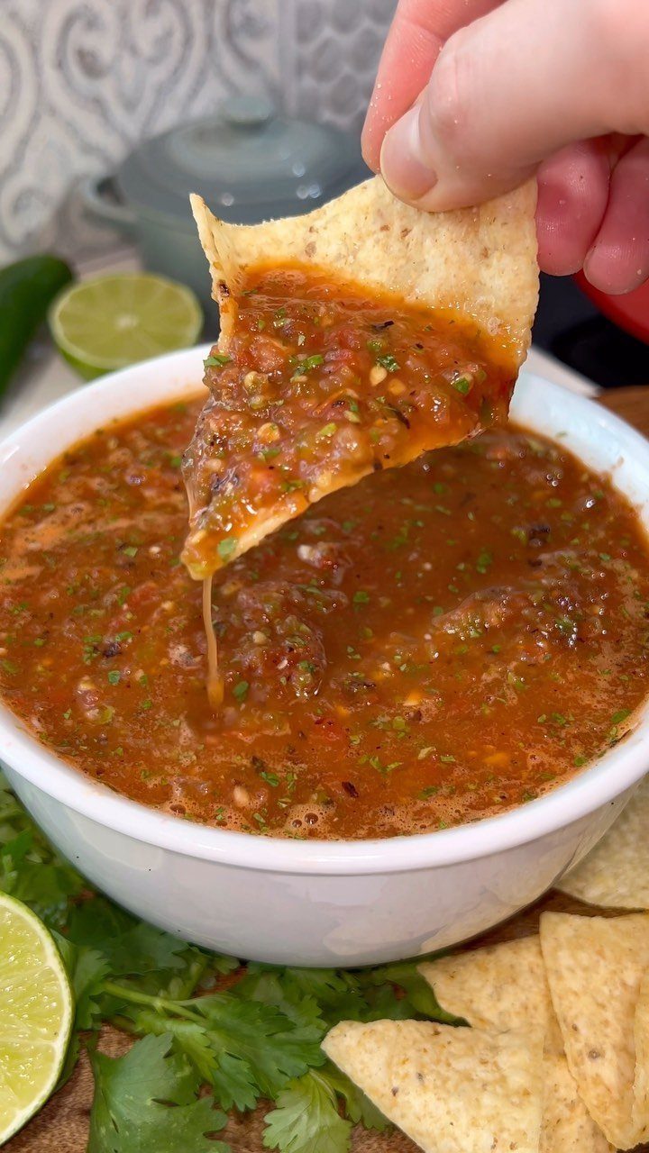 12 Useful Homemade Christmas Gifts People Will Use 9 Tortilla chip dipped in a bowl of chunky red salsa with lime wedges.