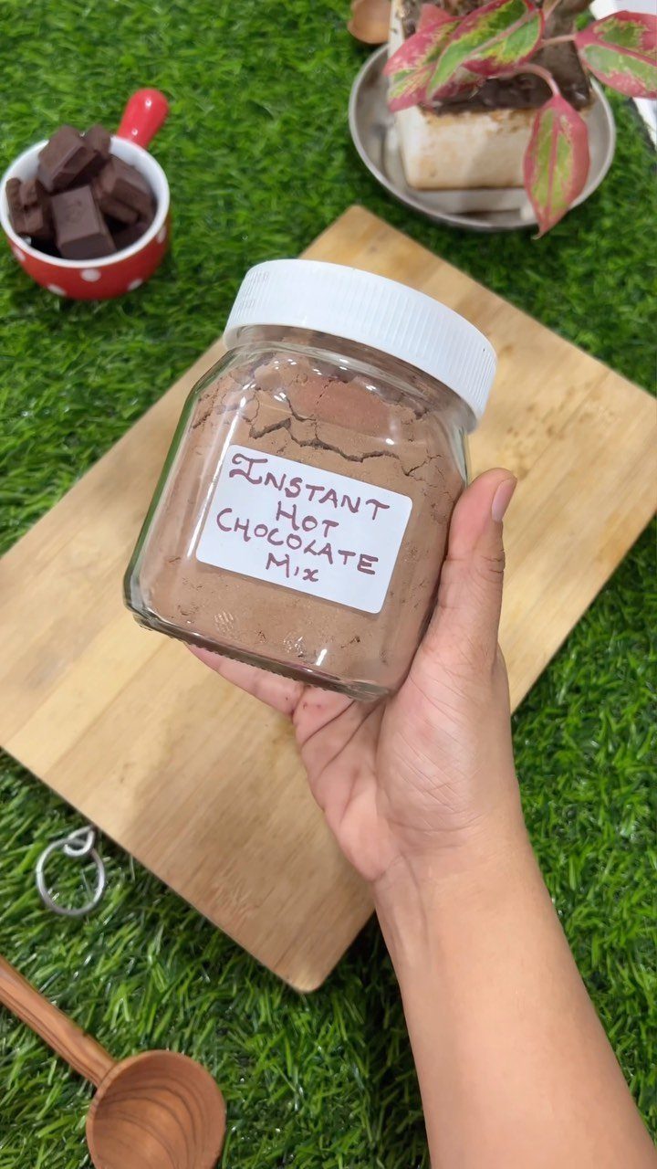 12 Useful Homemade Christmas Gifts People Will Use 2 Glass jar of homemade hot chocolate mix held over a wooden board.