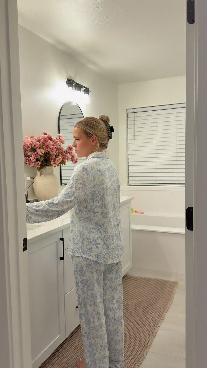 13 Warm and Cozy Gift Ideas for Winter Gifting 2 Woman wearing light blue patterned pajamas standing in a bright white bathroom.