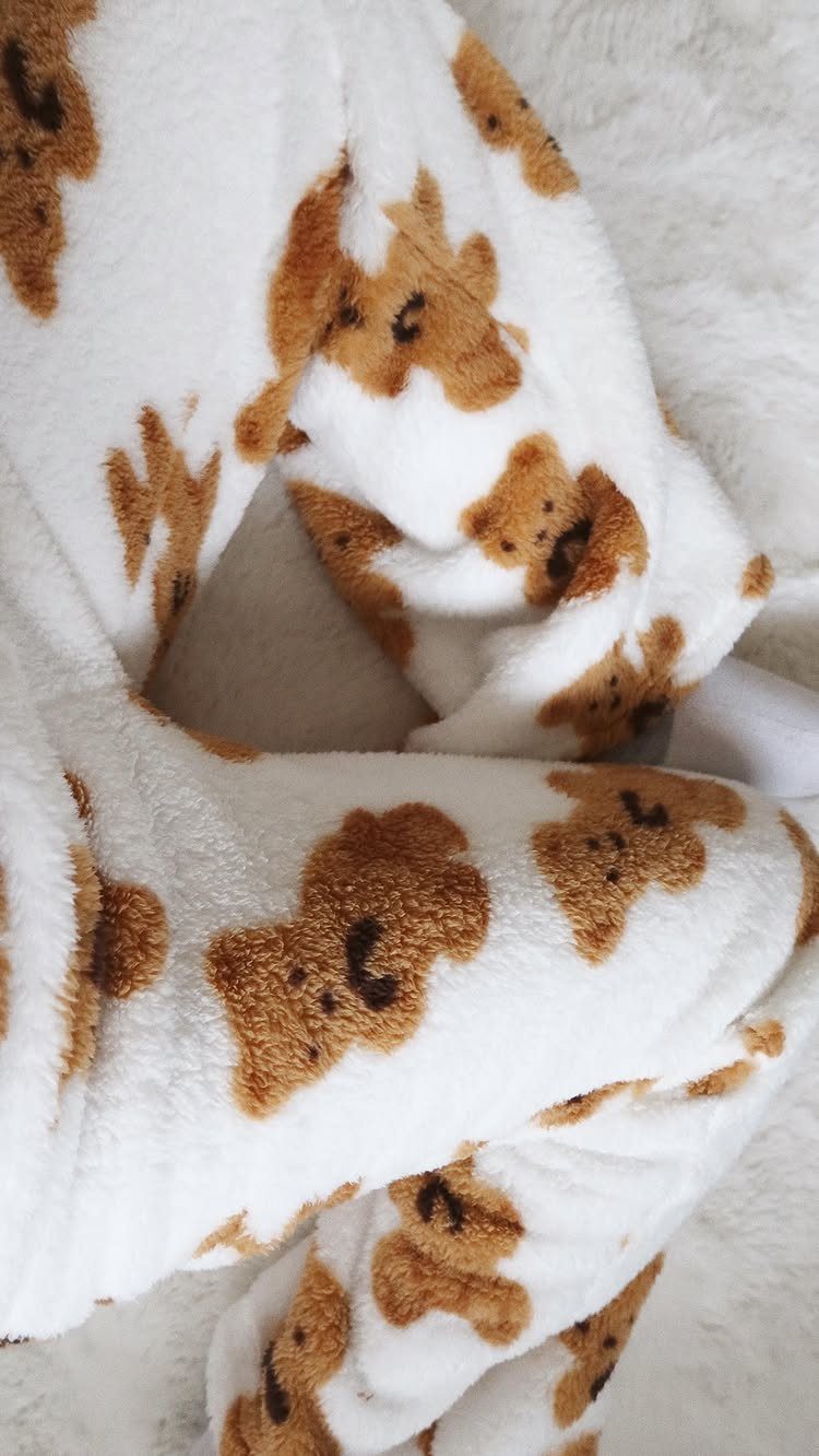13 Warm and Cozy Gift Ideas for Winter Gifting 7 White fleece pajama pants with brown teddy bear patterns on a fluffy background.