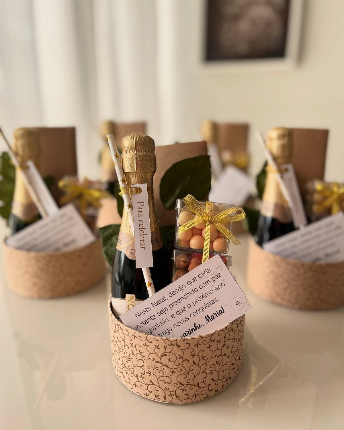 Mini sparkling wine bottles and yellow candies in patterned gift baskets with notes.