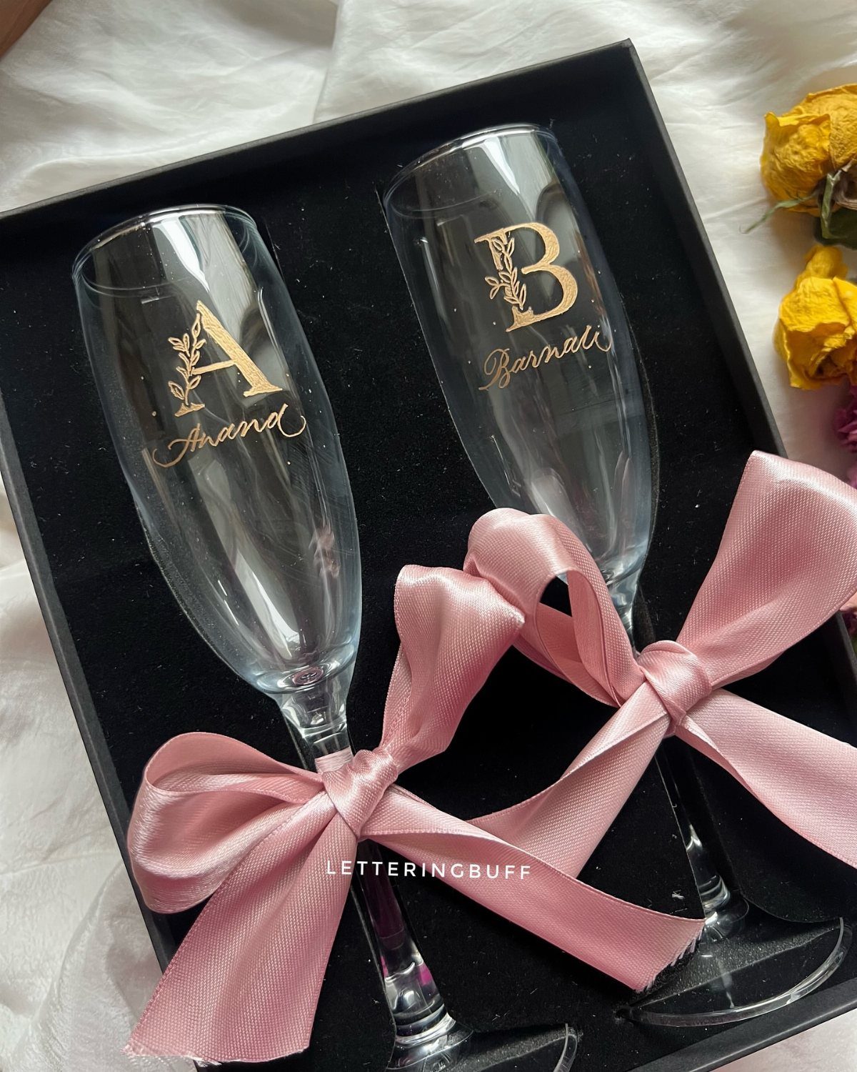 10 Wine Gift Ideas for Every Kind of Wine Lover 10 Two champagne flutes with gold personalized lettering tied with pink satin ribbons.