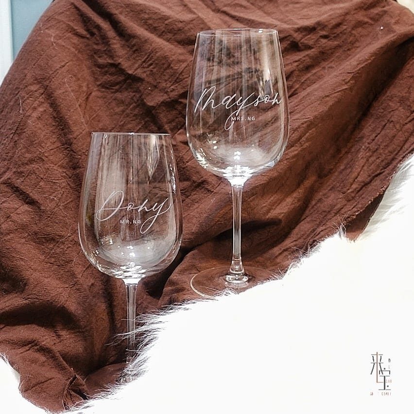 10 Wine Gift Ideas for Every Kind of Wine Lover 1 Two personalized wine glasses with etched names on a brown and white background.